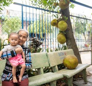 Nguyen Thi Den with her granddaughter, who contracted dengue, in the home of Thu Dau Mot