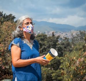 A community member in Cali, Colombia holds a mosquito release container